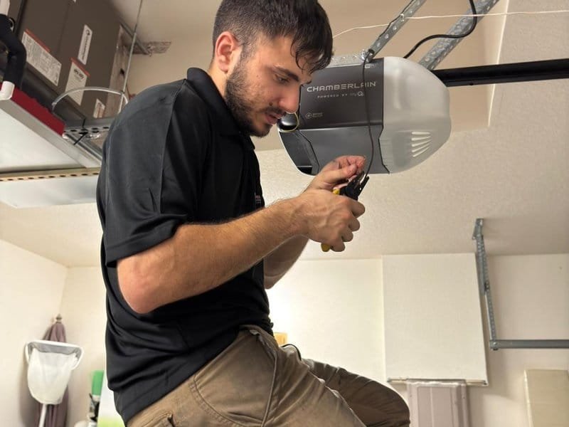 Technician using pliers on an opener motor