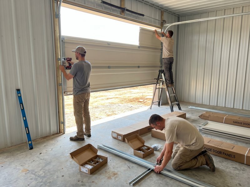 Installer on a ladder fitting a steel door
